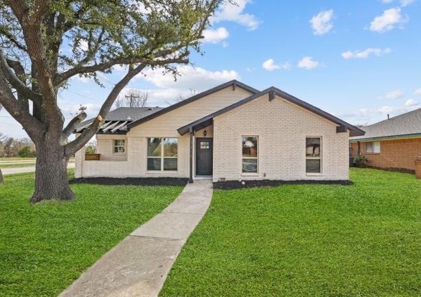 After: home with painted white brick, new windows and a black front door