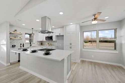 Renovated white kitchen with island and stainless range hood