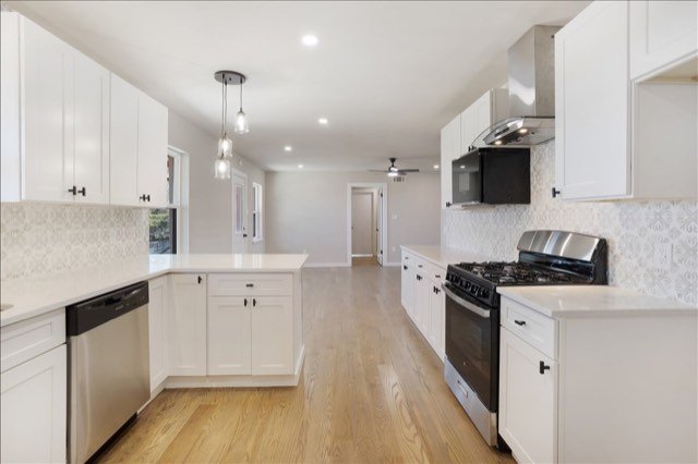 White kitchen with gas range and pendant lights