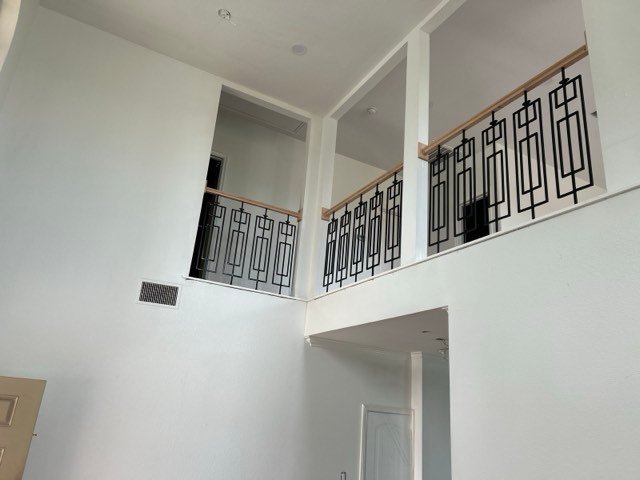 Custom black metal stair railing in a two-story room